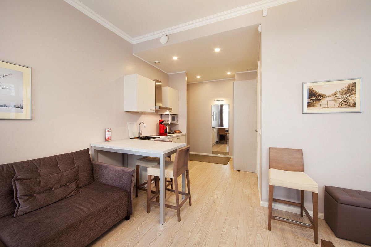 A compact living space with a kitchenette, a dining area, and a seating area.