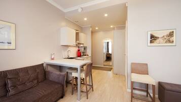 A compact living space with a kitchenette, a dining area, and a seating area.