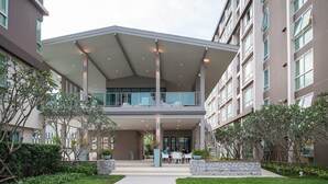 A modern building with a covered outdoor area, a staircase, and a landscaped garden. - Baan Peang Ploen by Montri (Hua Hin)