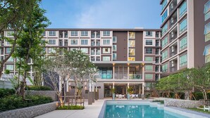 A modern hotel with a swimming pool, outdoor seating, and a well-maintained garden. - Baan Peang Ploen by Montri (Hua Hin)