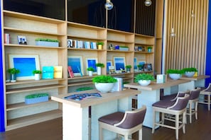Una biblioteca moderna con varias estanterías de madera, libros y plantas decorativas.