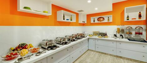 A buffet setup with various food items and serving utensils.