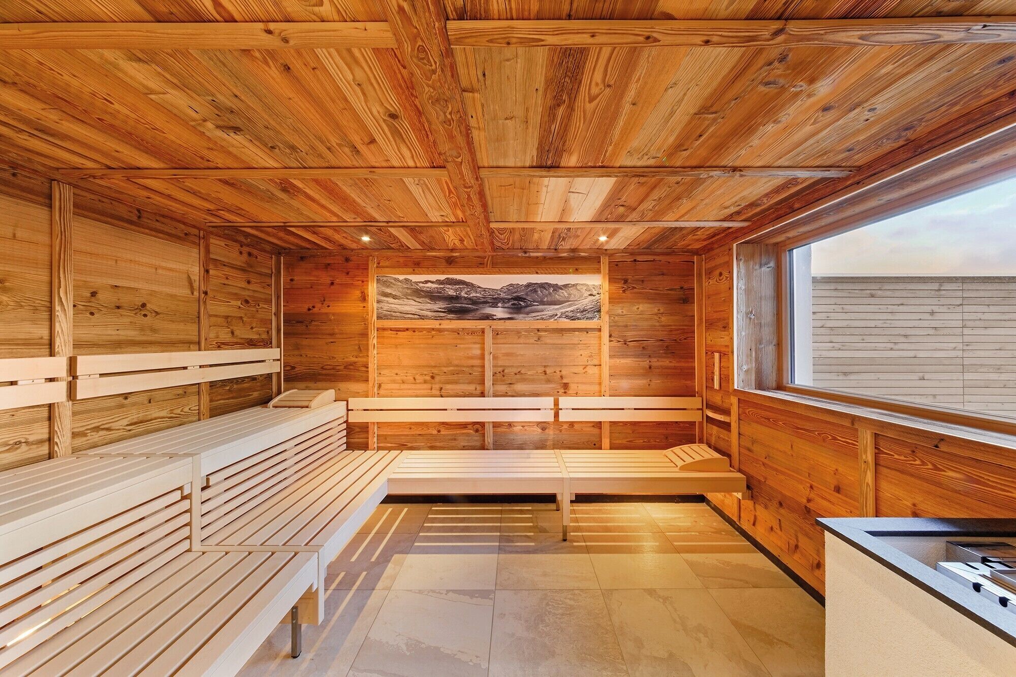 A sauna room with wooden benches and a large window.