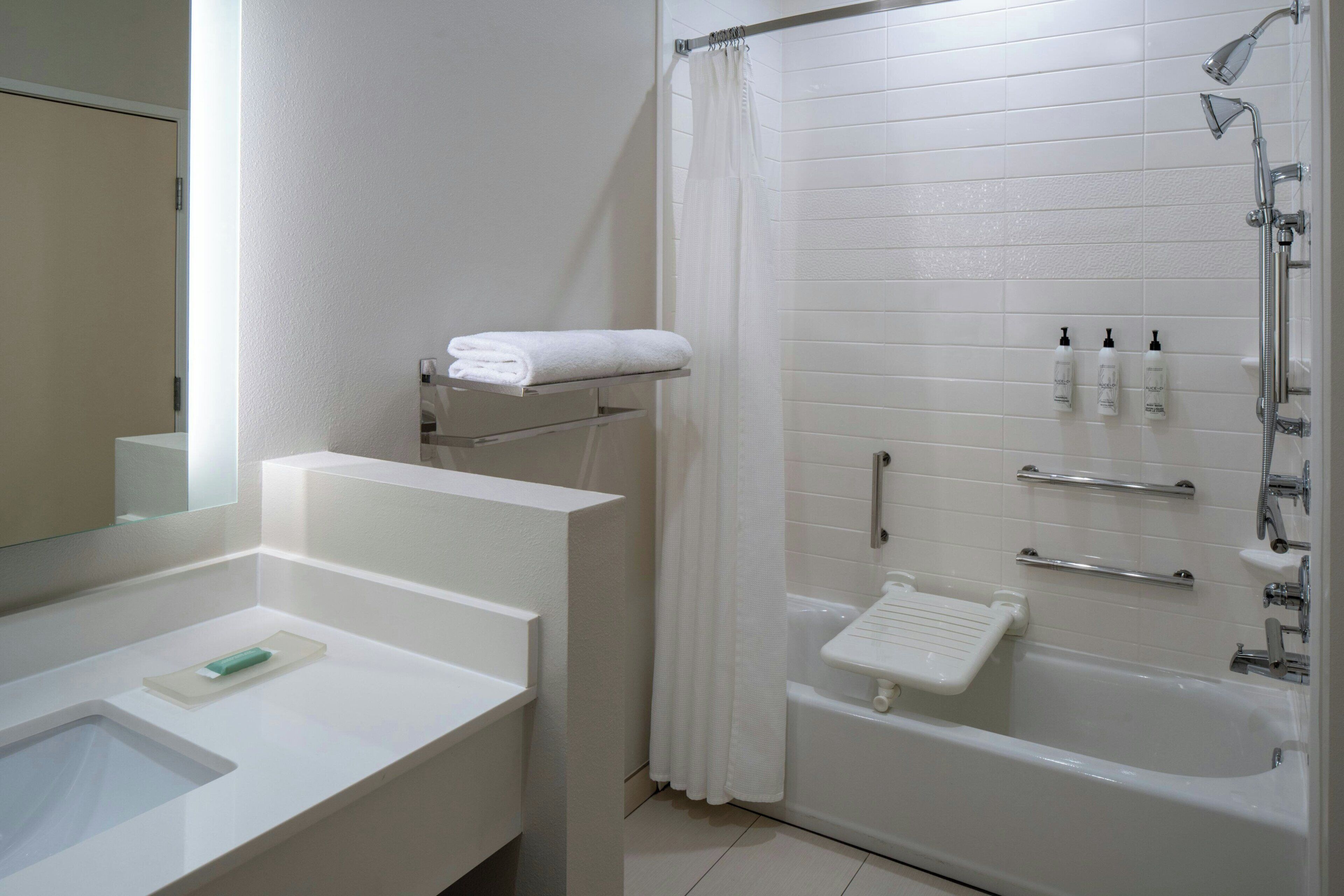 Un baño con bañera, ducha, lavabo y espejo.