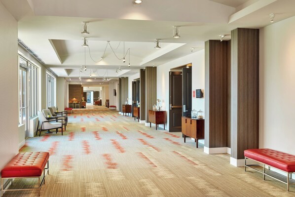 A spacious hotel lobby with a patterned carpet, seating areas, and modern lighting fixtures. - Four Points By Sheraton Dallas Fort Worth Airport North (Coppell)