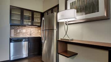 A modern kitchen with stainless steel appliances, a dishwasher, and a wooden countertop.