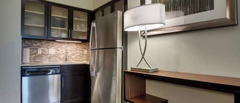 A modern kitchen with stainless steel appliances, a dishwasher, and a wooden countertop.