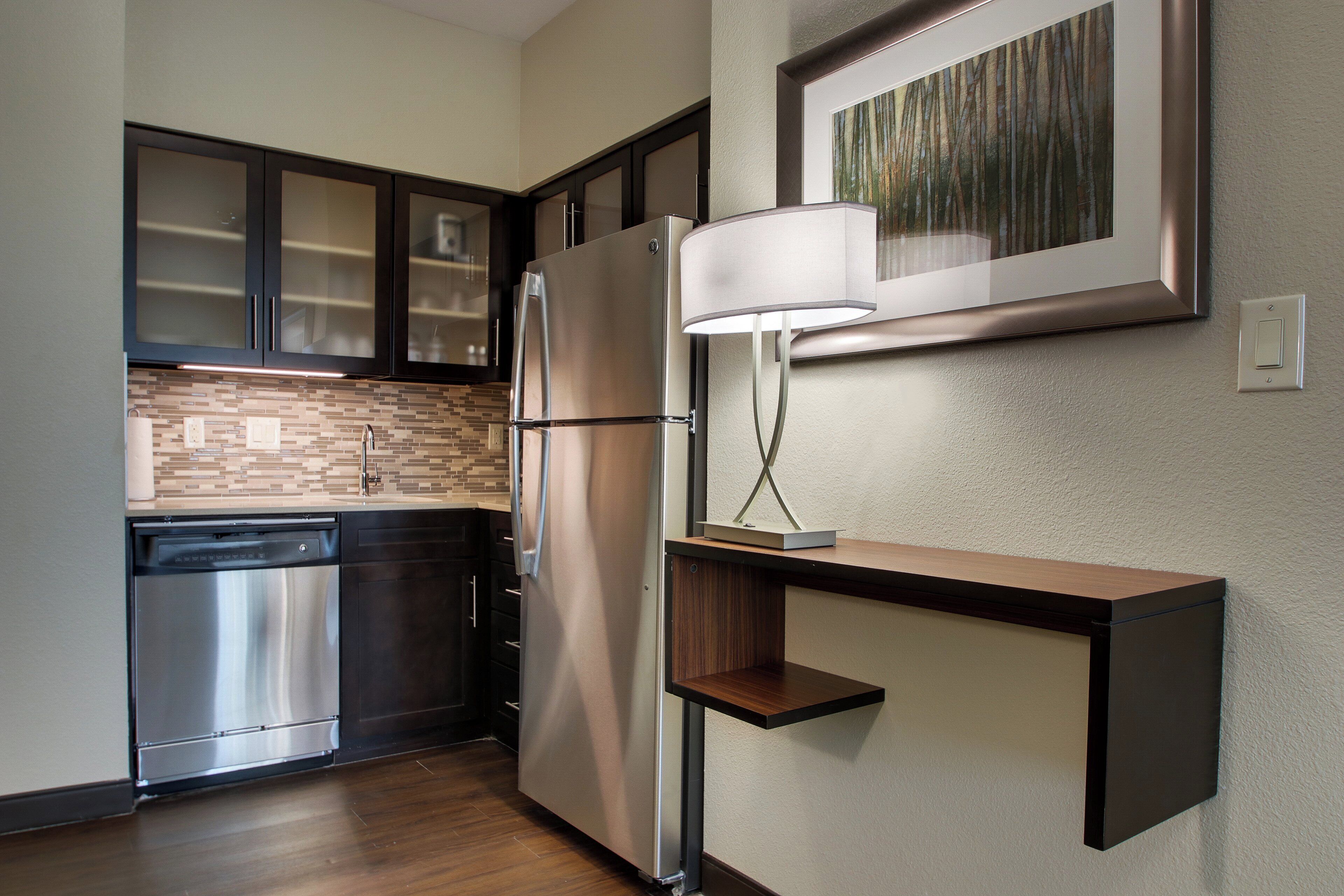 A modern kitchen with stainless steel appliances, a dishwasher, and a built-in oven.