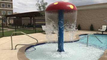 Una piscina al aire libre, sillones reclinables de piscina