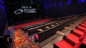 A modern cinema with red seats and a large screen displaying "Only at Galaxy Theatres". - Staybridge Suites Plano - The Colony by IHG (The Colony)