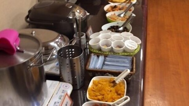Una mesa de buffet con diversos alimentos y utensilios.