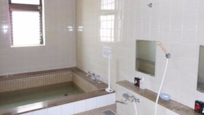 Un baño con bañera, ducha, lavabo y espejo.