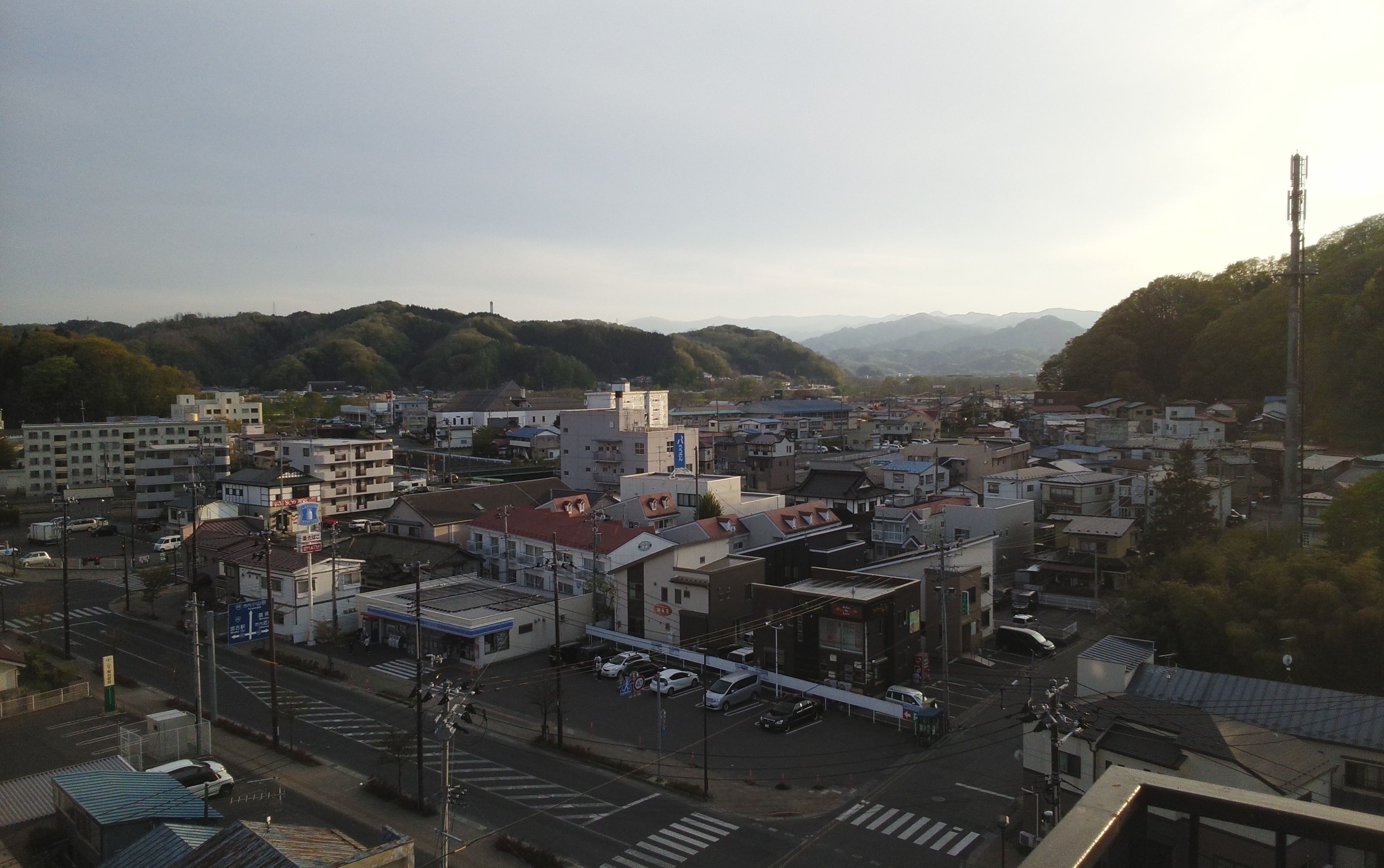 Un paisaje urbano con edificios, calles y montañas al fondo.