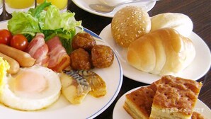 Een tafel met diverse ontbijtartikelen, zoals rijst, eieren, worstjes en brood.
