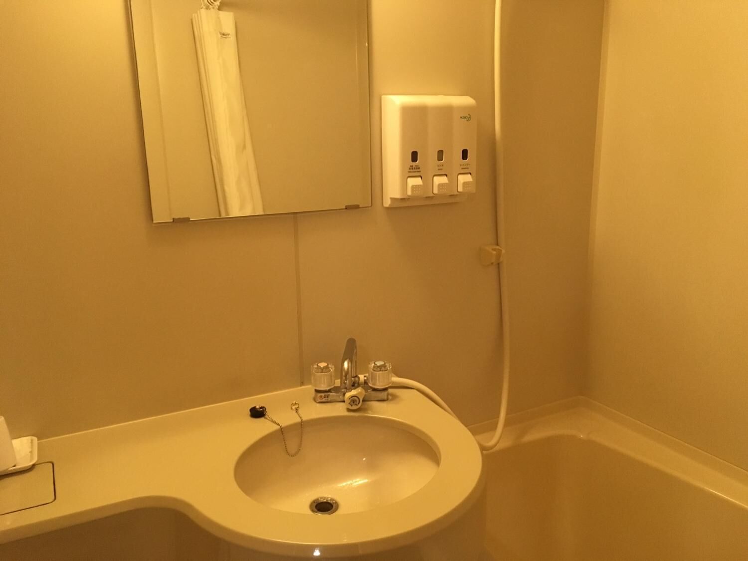 A bathroom with a white sink, a mirror, and a shower.