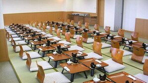 Une pièce de style japonais traditionnel, avec un sol recouvert de tatamis, de petites tables basses et des sièges rembourrés.