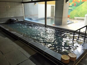 A rectangular indoor pool with clear water, surrounded by stone tiles and a glass barrier. - Breezbay Hotel & Resort Gero (Gero)