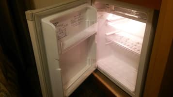 Un refrigerador abierto con dispensador de agua y compartimento congelador.
