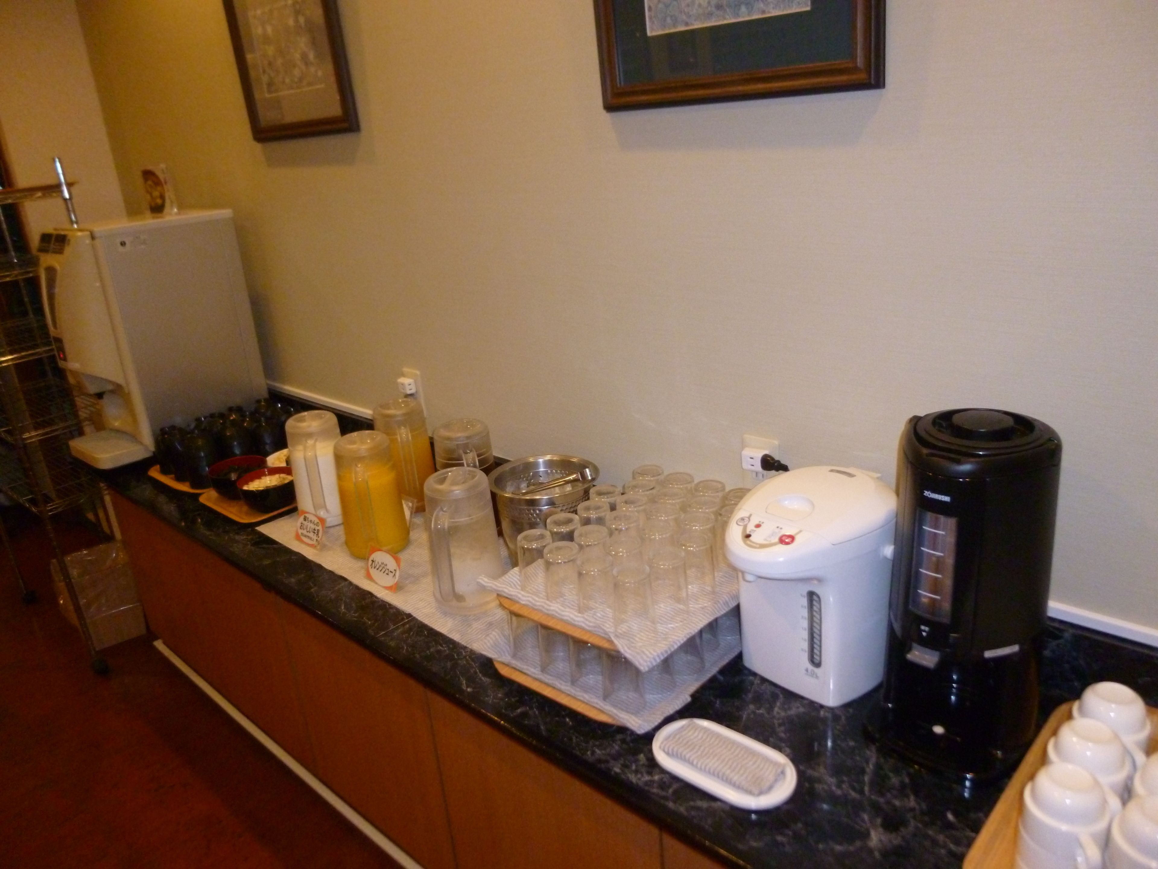 Una encimera de cocina con diversos objetos, como una cafetera, una licuadora y varios recipientes.