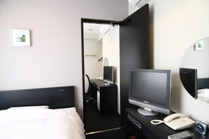 A hotel room with a bed, a desk with a computer and phone, and a mirror. - Hotel Crown Hills Kimitsu (Kimitsu)