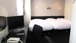 A hotel room with a bed, a desk with a computer, a phone, and a TV. - Hotel Crown Hills Kimitsu (Kimitsu)