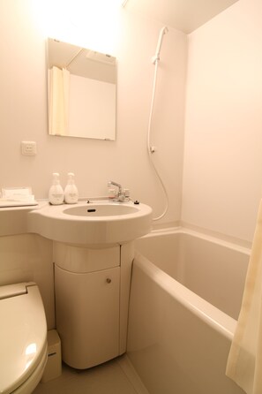 A bathroom with a sink, mirror, toilet, and bathtub. - Hotel Crown Hills Kimitsu (Kimitsu)