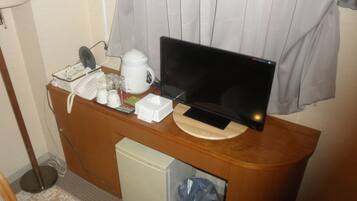 A small kitchenette with a microwave, coffee maker, and a small refrigerator.