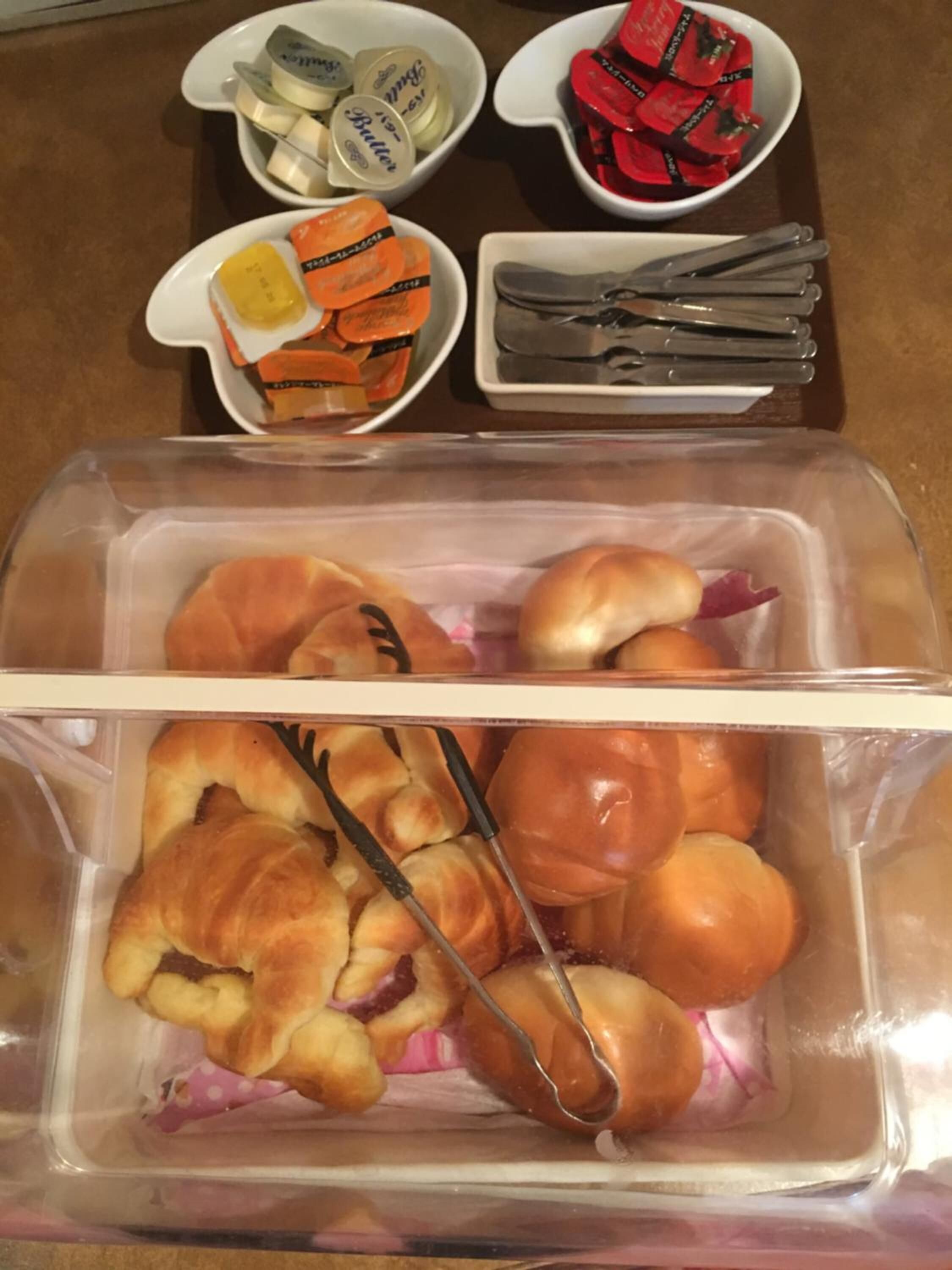 Comida con panecillos, mantequilla y mermelada.