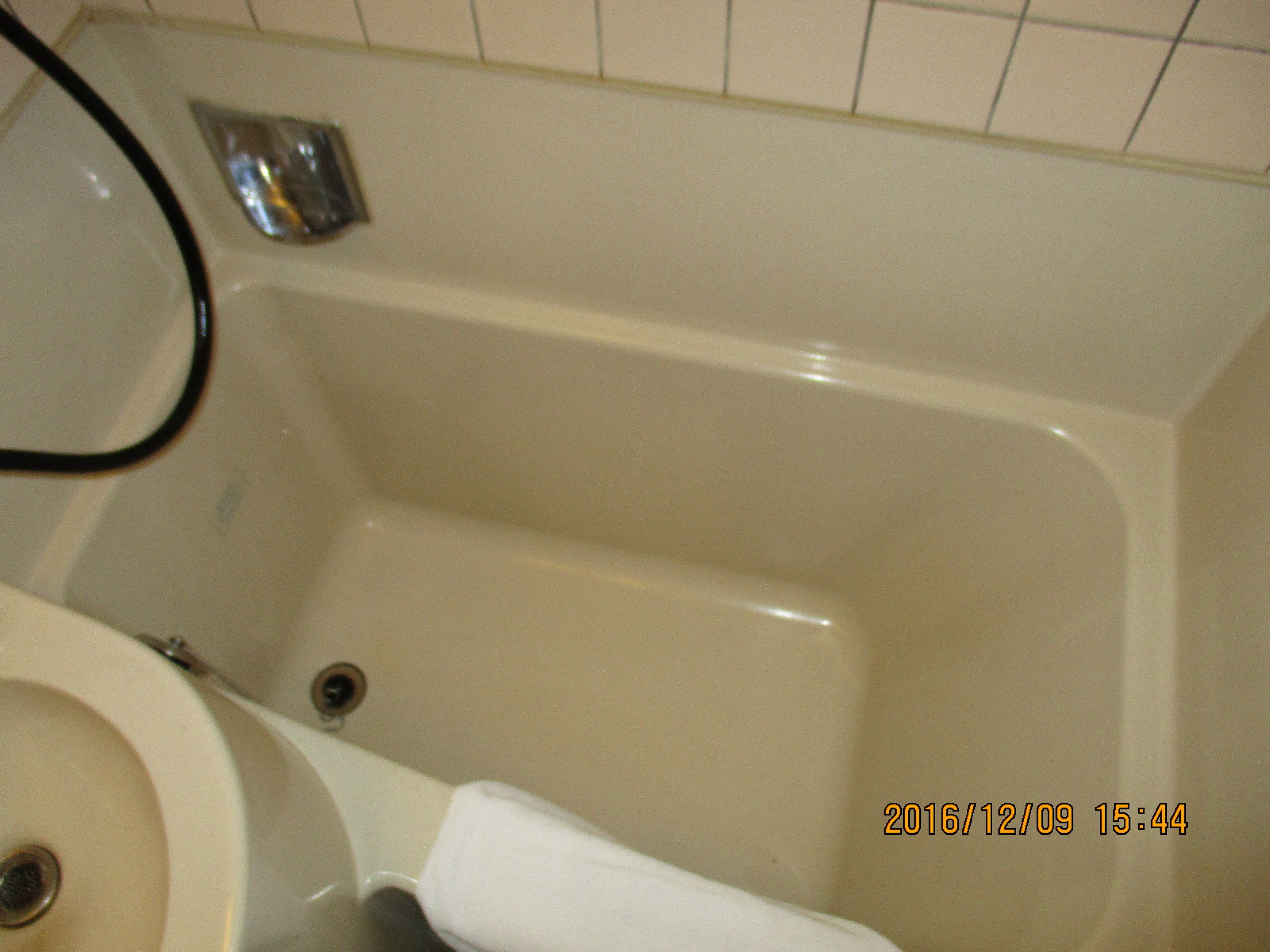 A bathtub with a white sink and a toilet.