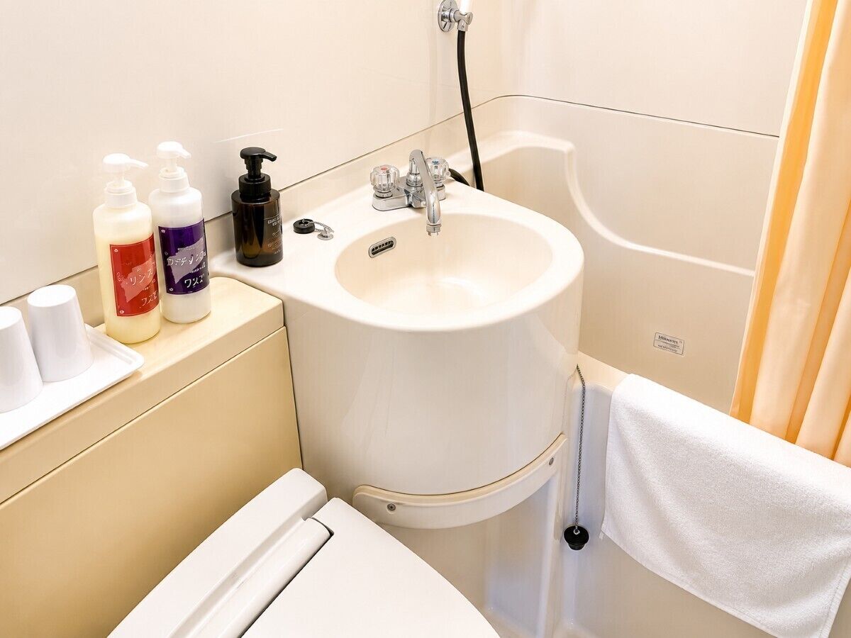 A bathroom with a sink, toiletries, and a towel rack.
