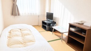 Habitación de hotel con cama, escritorio con computadora, silla y una pequeña mesa con un mapa.