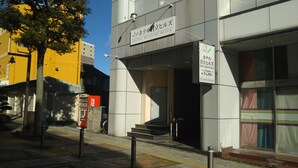 A modern hotel entrance with a clear sign indicating the name and contact information. - Hotel Hitachi Hills (Hitachi)