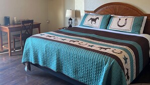 Ein ordentlich eingerichtetes Schlafzimmer mit Bett, Schreibtisch und Stuhl.