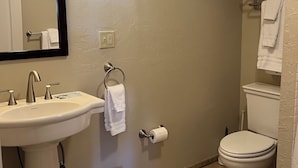 Ein Badezimmer mit Waschbecken, Spiegel, Toilette und Mülleimer.
