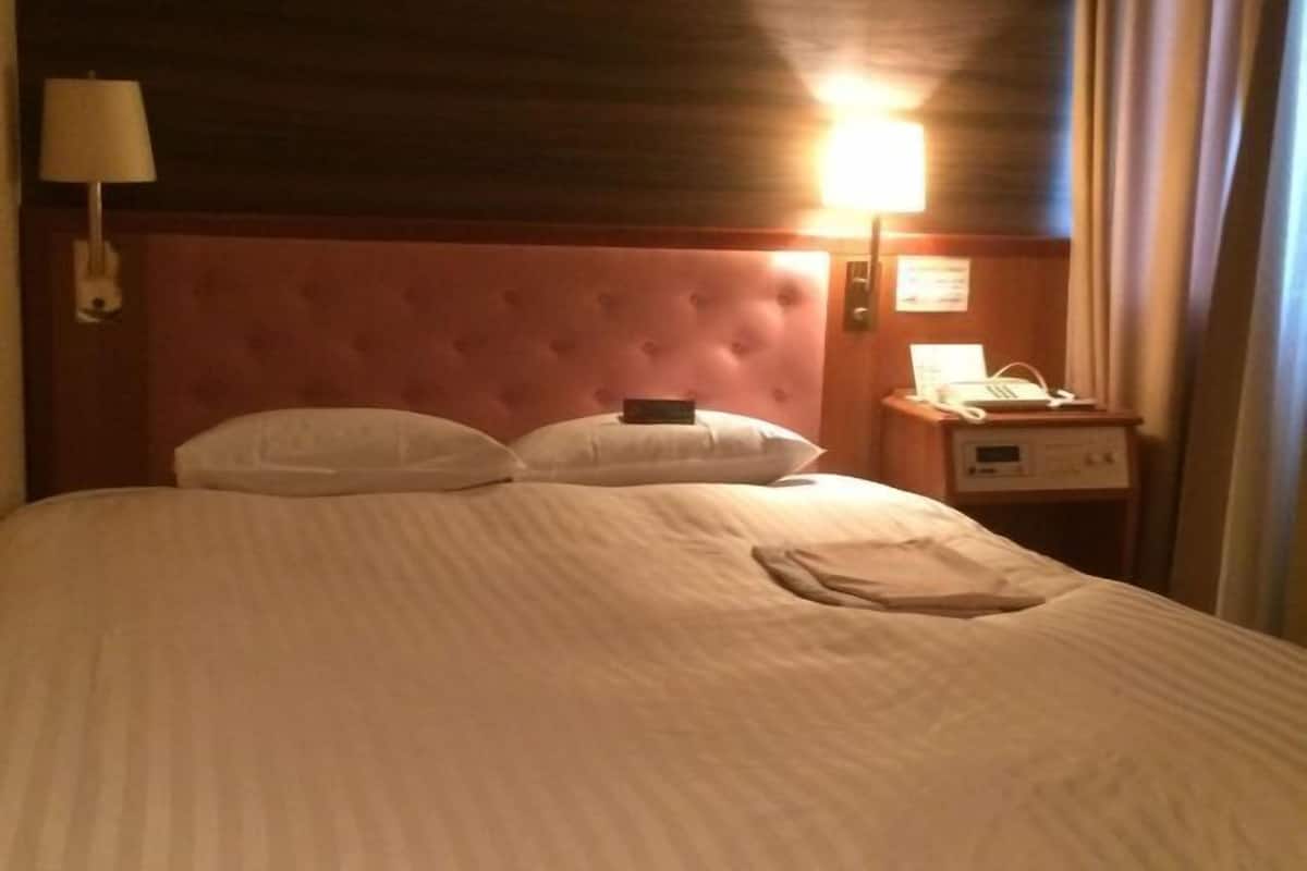 Escritorio, cortinas blackout y tabla de planchar con plancha