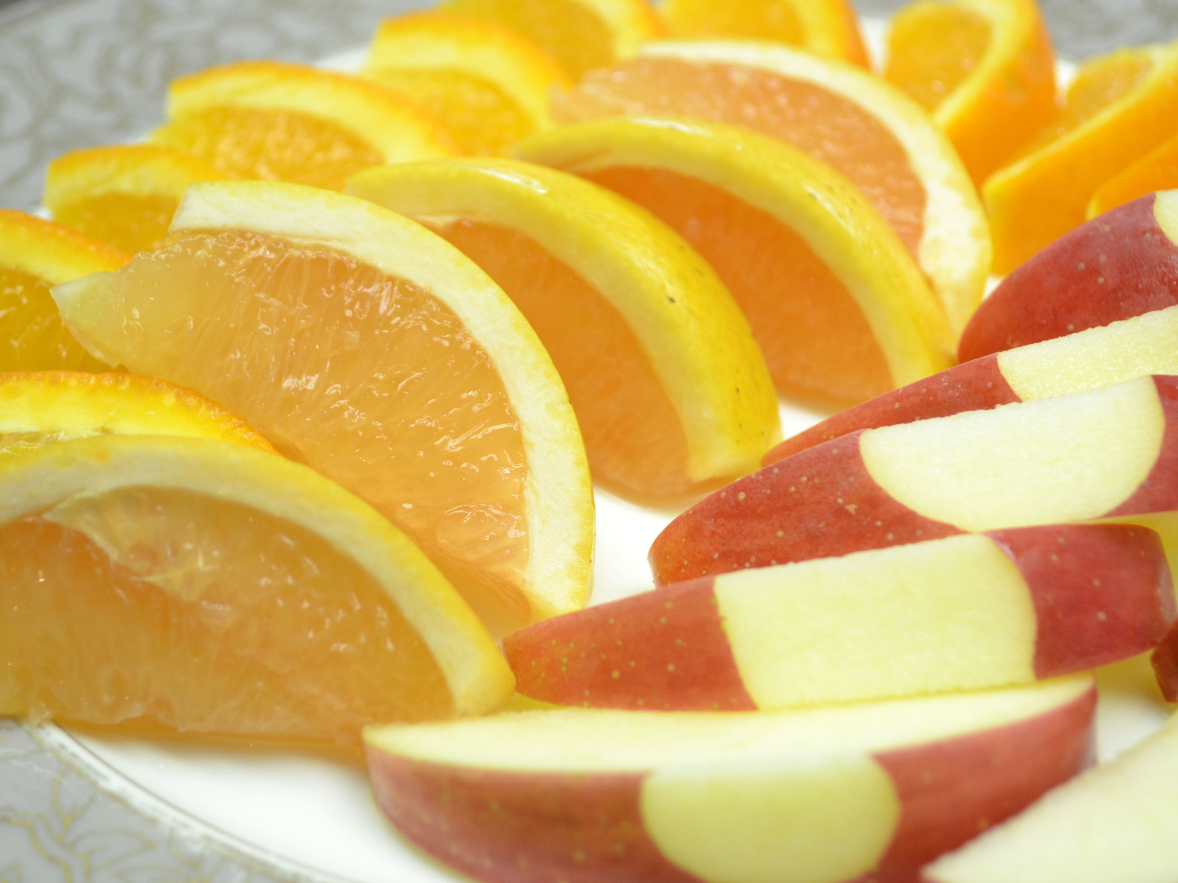 A plate of sliced oranges and apples.