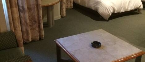 Una habitación de hotel con una cama, una mesita, una silla y un sofá.