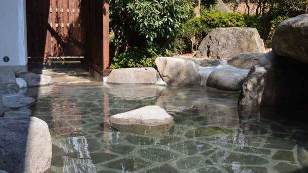 A clear water feature with rocks and a wooden structure in the background. - Harazuru Grand Sky Hotel (Asakura)