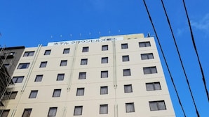 Een meerlaags hotel met een gelijkmatige gevel, veel ramen en zichtbare leidingen.