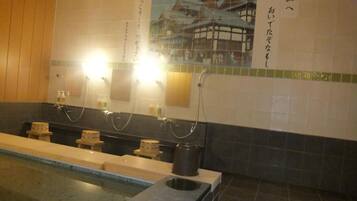 Traditional Japanese-style bathroom with a long bathtub, two sinks, and a framed picture of a traditional Japanese building.