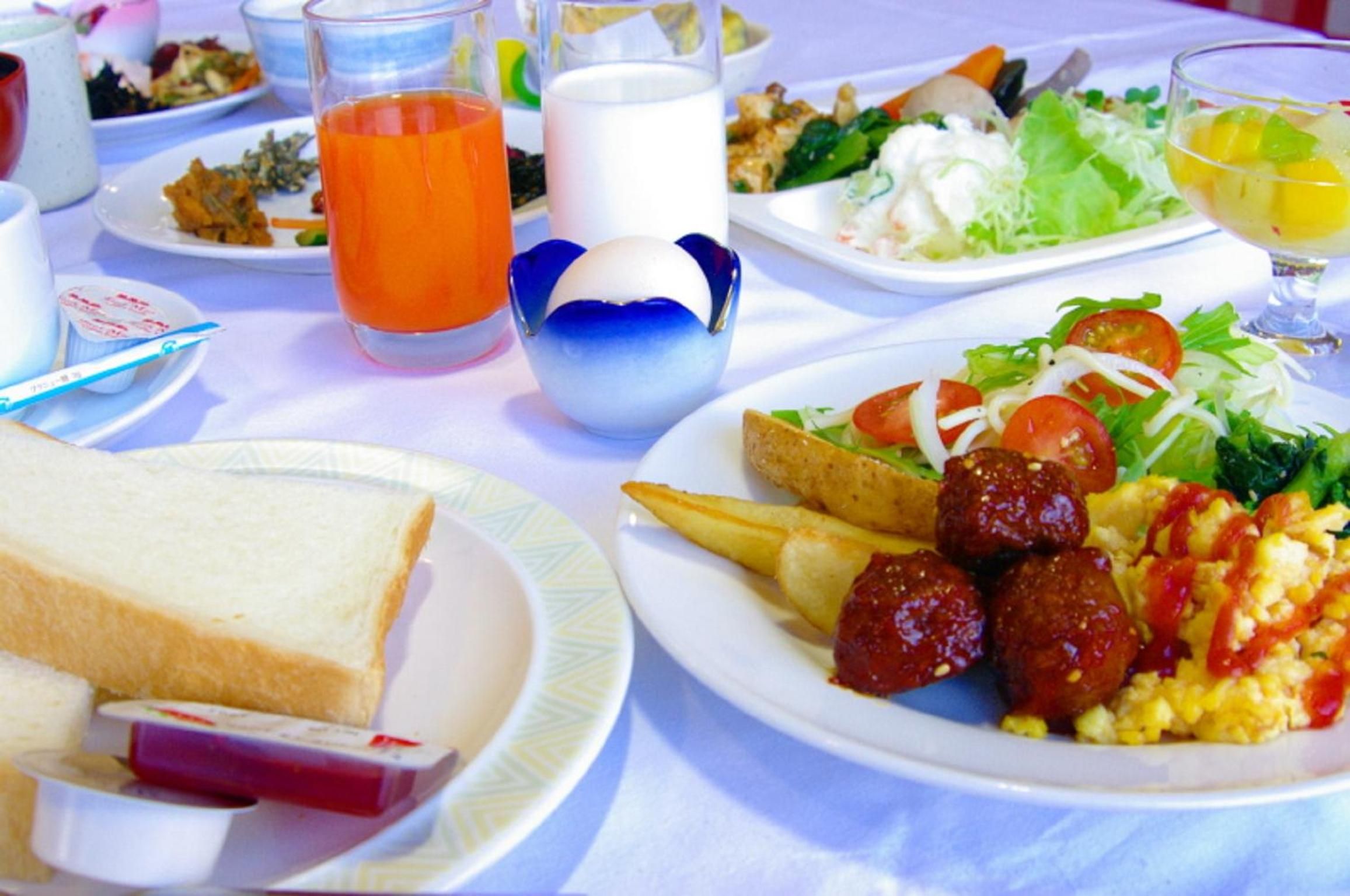 A dining table with various dishes including a plate of fries, a salad, and a slice of toast.