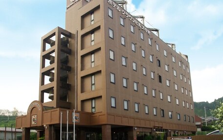 A multi-story hotel with a central atrium, a flat roof, and a sign indicating it is a hotel.