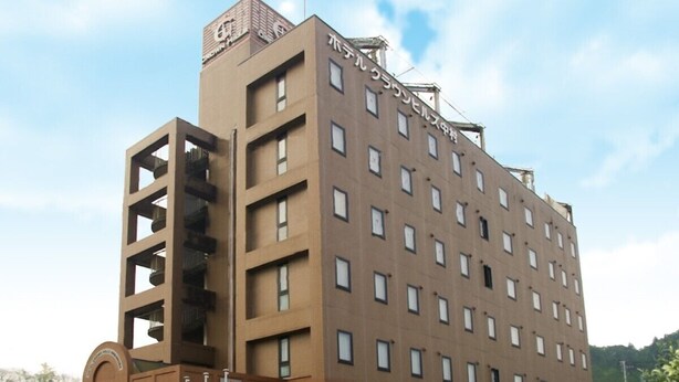 A multi-story hotel with a central atrium, a flat roof, and a sign indicating it is a hotel.