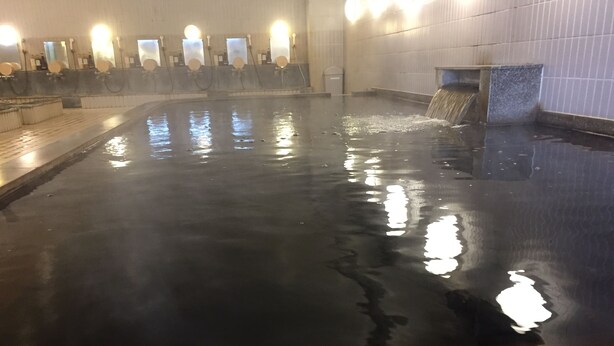 Una piscina techada con múltiples fuentes y luces empotradas.