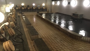 Zona de baños públicos con varias bancas y una piscina central.