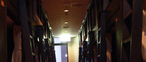 A hallway with wooden flooring and bookshelves on both sides.