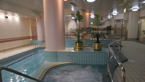 An indoor swimming pool with a hot tub, surrounded by tiled walls and columns, and potted plants. - Resort Capsule Sakuragicho (Yokohama)