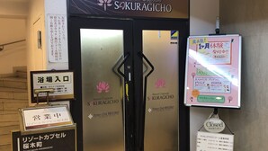A building entrance with a sign for Resort Capsule SAKURAGICHO, a fitness club, and a closed sign. - Resort Capsule Sakuragicho (Yokohama)
