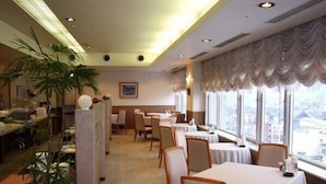 A restaurant with tables and chairs arranged for dining. - Hotel Crown Hills Takefu (Echizen)