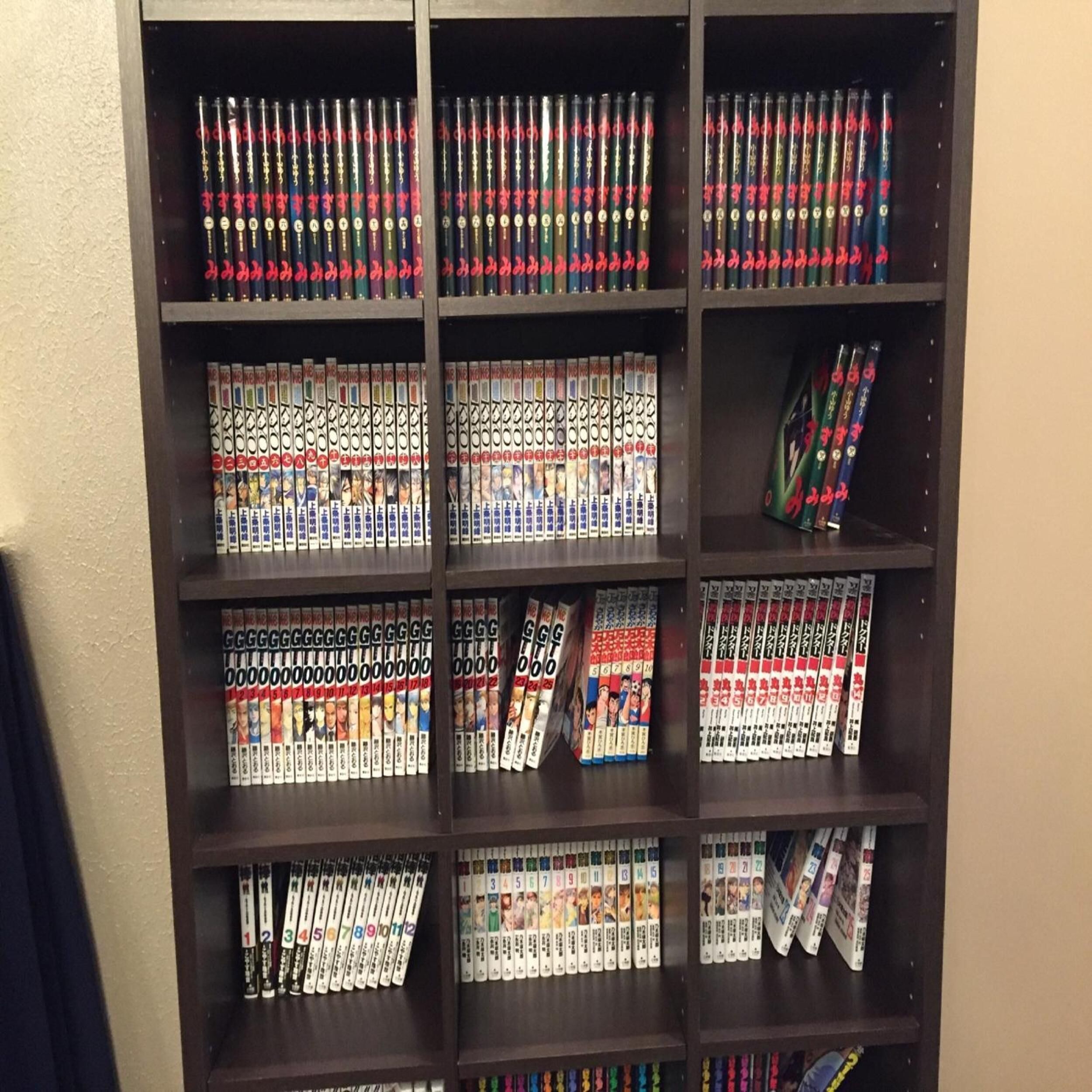 Una estantería con volúmenes de manga organizados por serie y número de volumen.
